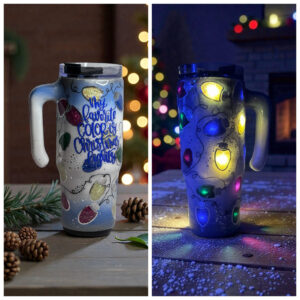 Travel mug with hand-painted Christmas lights that glow in the dark, pinecones and bokeh lights around.