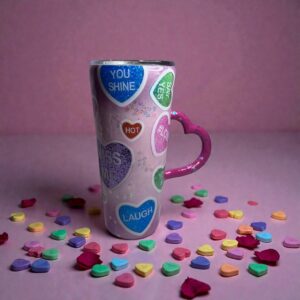 Tall pastel mug with colorful conversation hearts and a pink heart-shaped handle